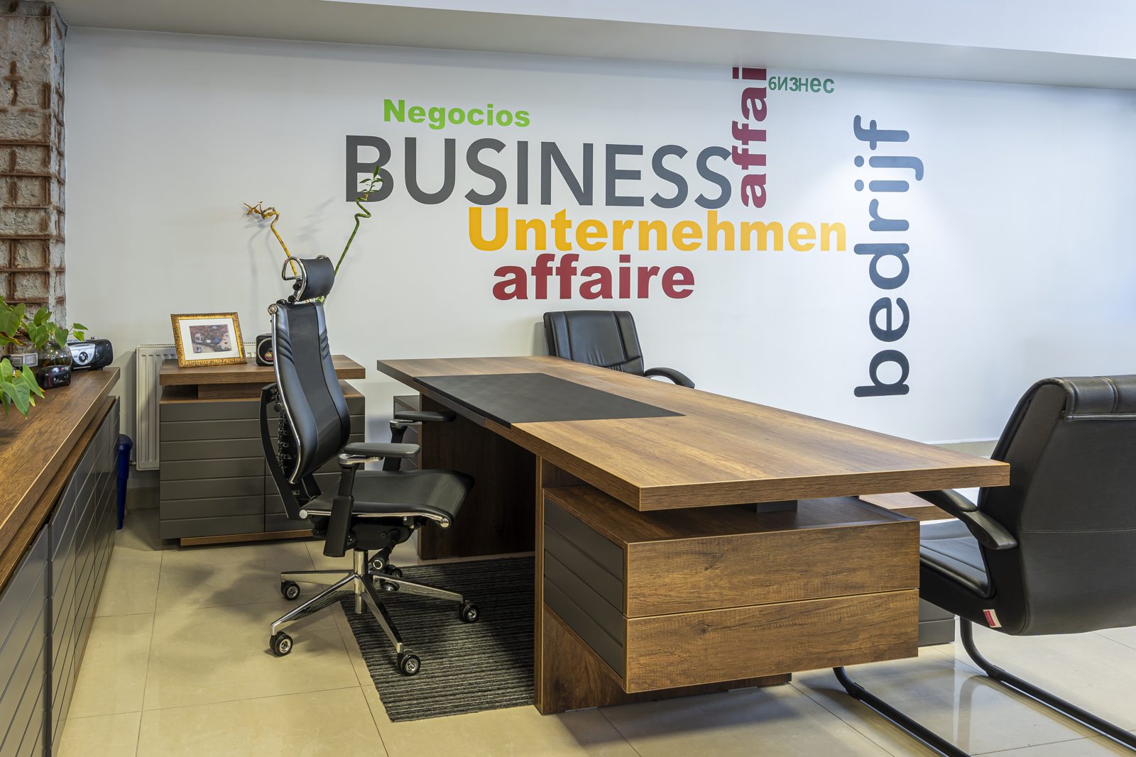 Showroomda ahşap yönetici masası ve ergonomik koltuk düzeni